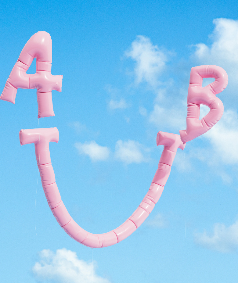 Ein rosa Frisbee mit Incharge-Aufklebern schwebt durch einen klaren blauen Himmel.